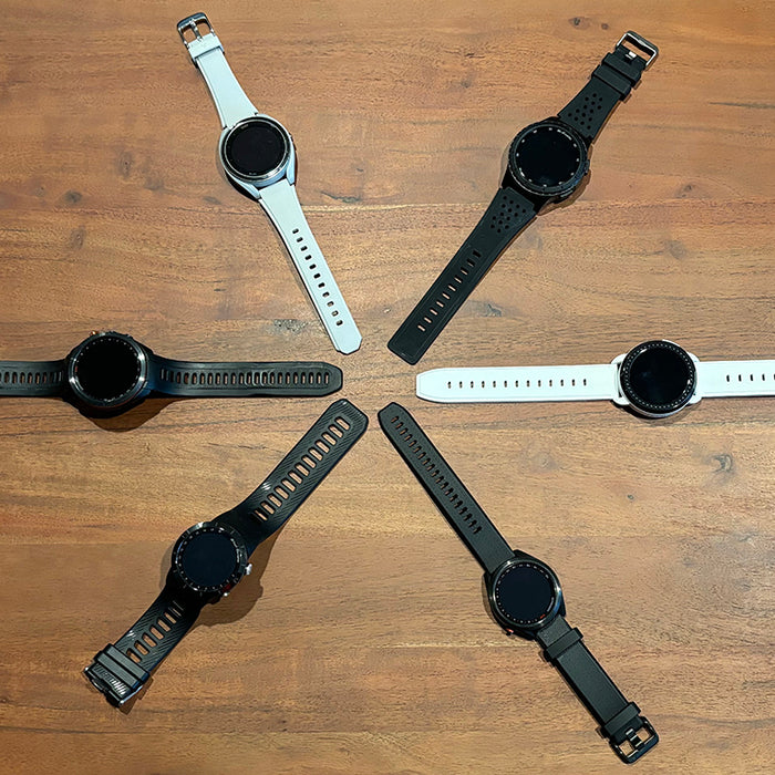 Six white and black golf watches in a star shape on a hardwood floor