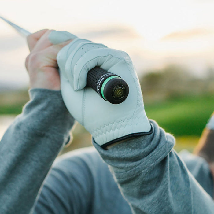 A golfer with a club over his shoulder with an Arccos Smart Sensor on the end of it