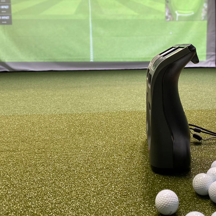The Bushnell Launch Pro next to the Foresight GC3 in a golf simulator next to golf balls