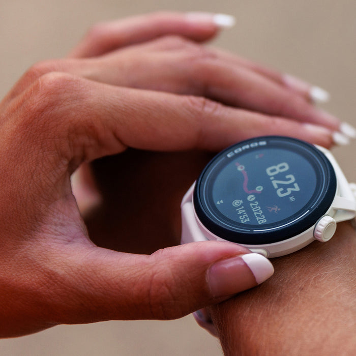 A closeup of a white COROS PACE 3 watch on a woman's wrist with her other hand adjusting the breadcrumb route on the display