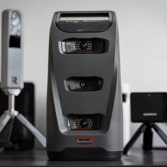 The Bushnell Launch Pro in front of several other golf launch monitors at PlayBetter