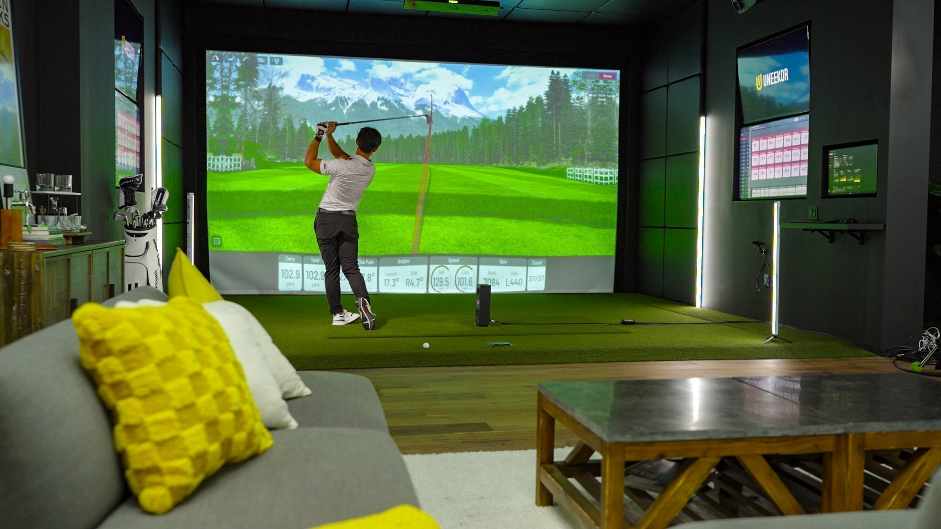 Golfer in a Uneekor Eye Mini Lite golf simulator