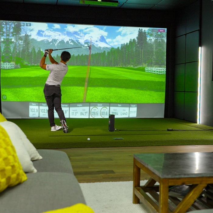 Golfer in a Uneekor Eye Mini Lite golf simulator