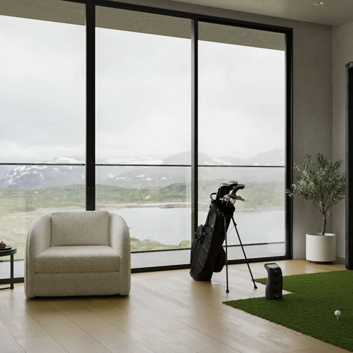 A Foresight Sports golf simulator studio in a luxury apartment with a back wall with a view to an outdoor scene