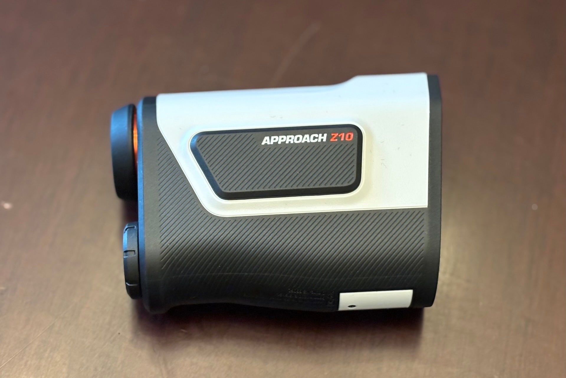 The Garmin Approach Z10 golf rangefinder on a woodgrain surface