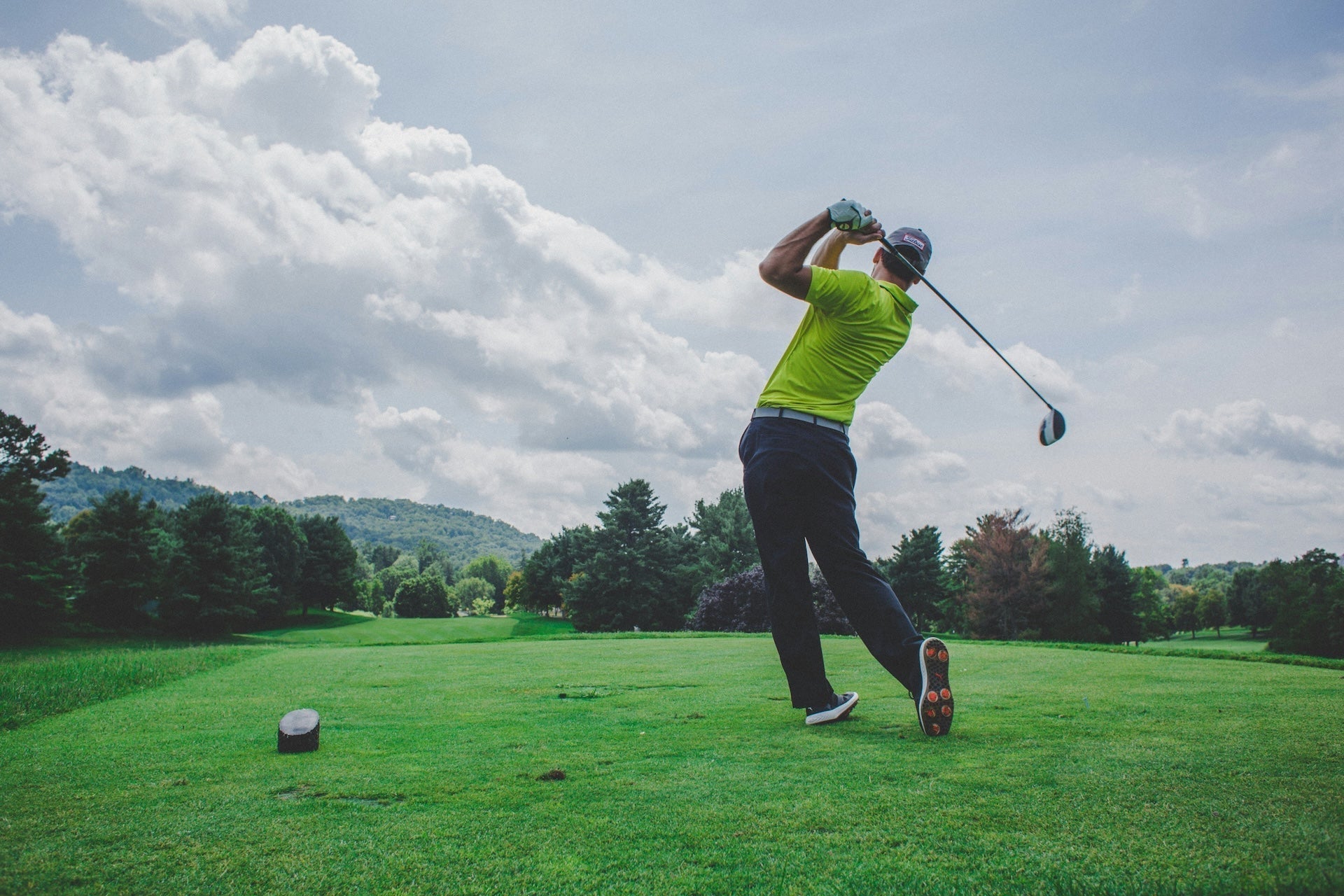 Golfer just after swinging driver on a golf course