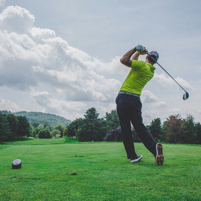 Golfer just after swinging driver on a golf course