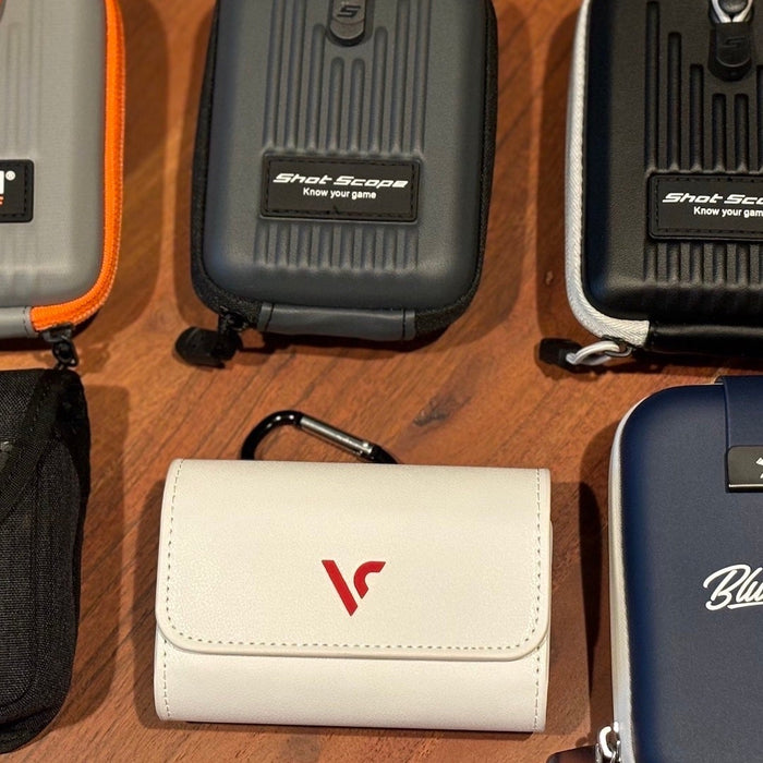 Six golf rangefinder cases with various top golf brand names on them on a woodgrain surface