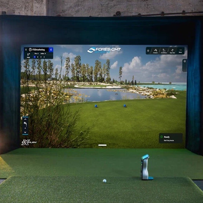 A Foresight Sports golf simulator with the QuadMAX launch monitor and a large impact screen and enclosure with Foresight virtual golf simulation software on it