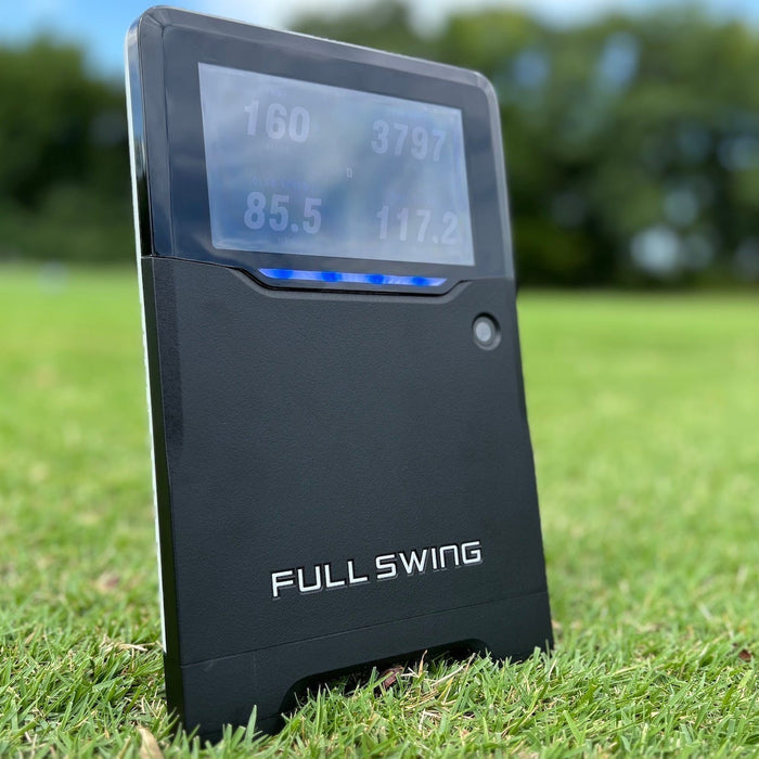 The Full Swing KIT golf launch monitor on the green grass on a bright day at the golf course (image by PlayBetter golf reviewer Marc) 