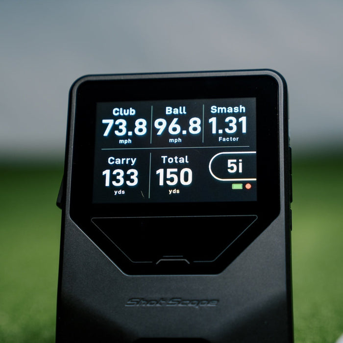 The Shot Scope LM1 launch monitor on a golf hitting mat with golf balls