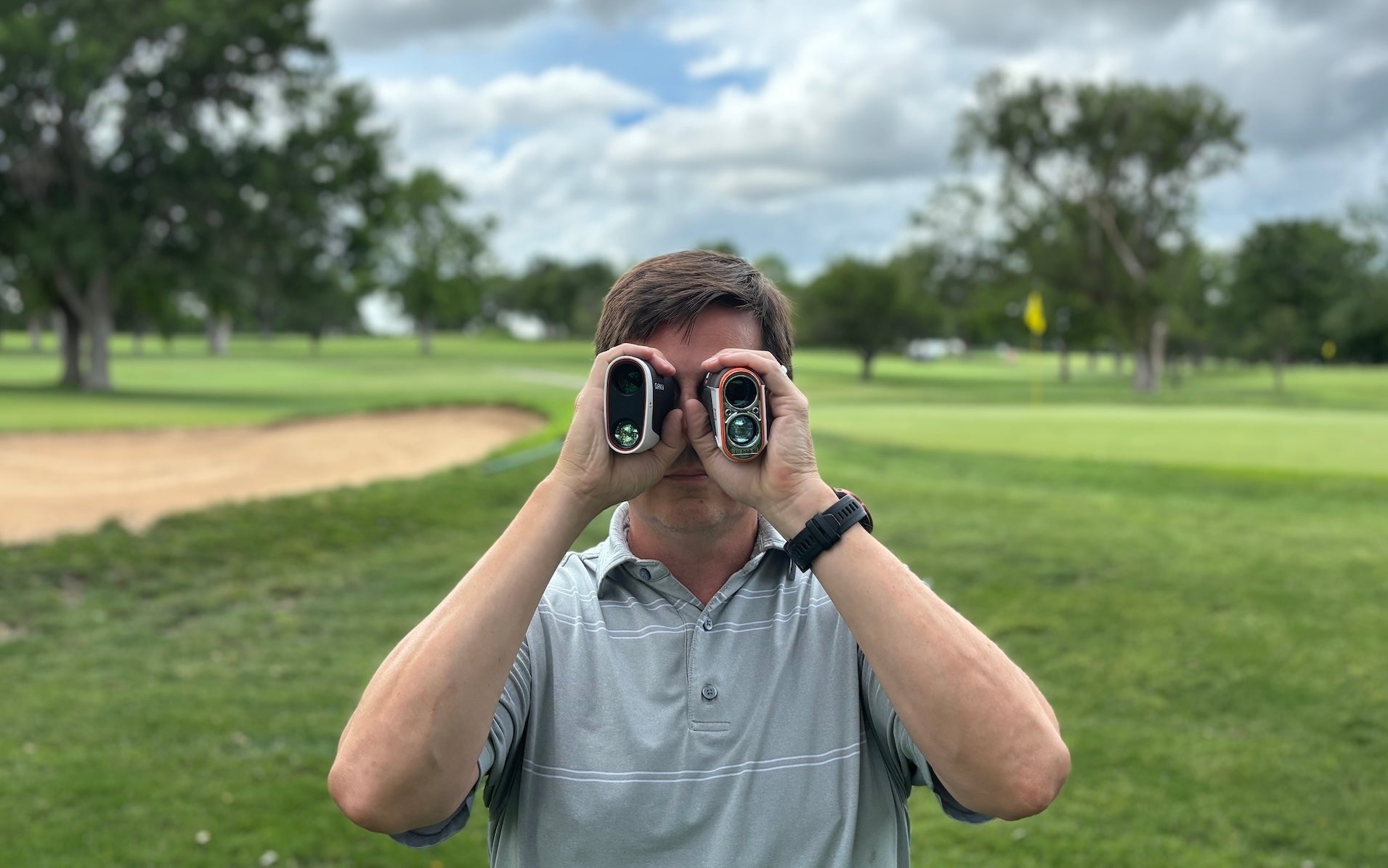 Golf reviewer Marc using two golf rangefinders on the golf course