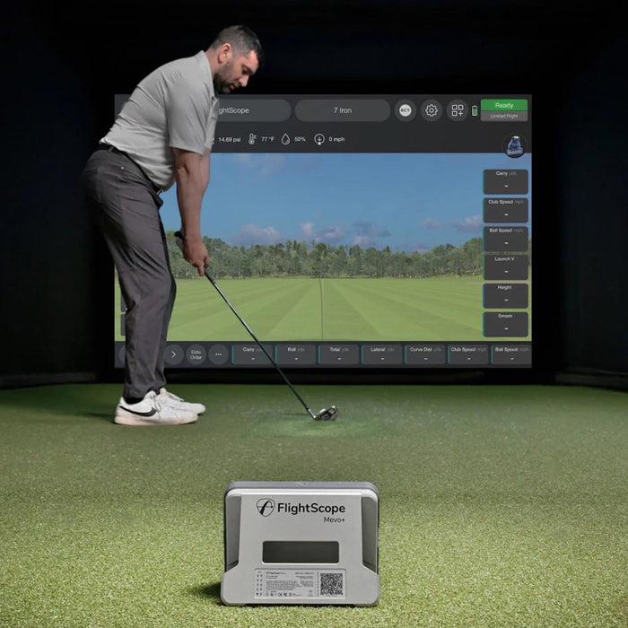 A golfer getting ready to swing in a golf simulator with a FlightScope Mevo+ launch monitor