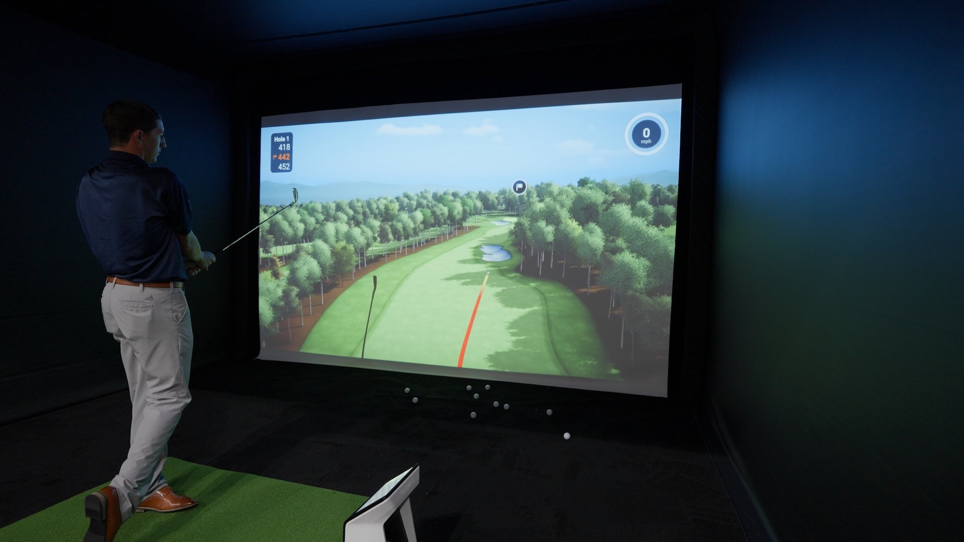 PlayBetter golf sim expert Daniel in the Garmin golf simulator trying out the upgraded Home Tee Hero software with an R50 and R10 at the 2026 PGA Show