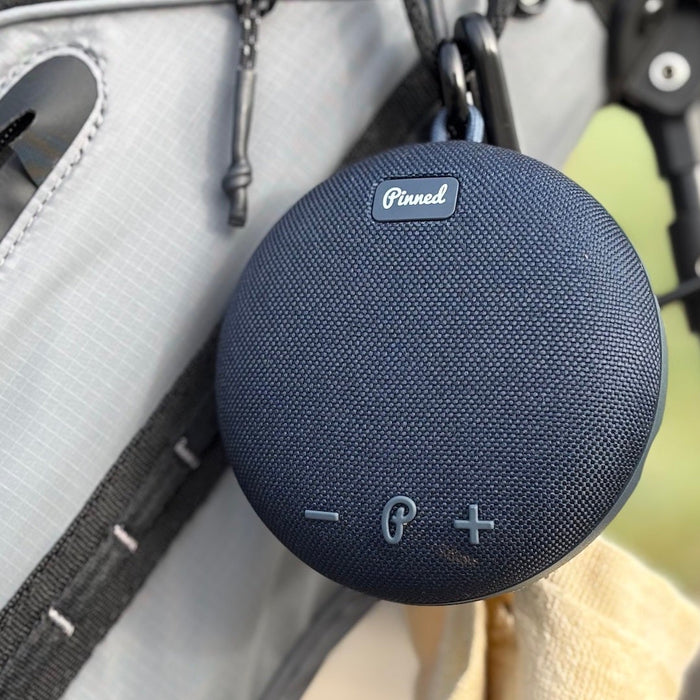 The Pinned Golf Dart 2.0 golf speaker hanging on reviewer Marc's golf bag