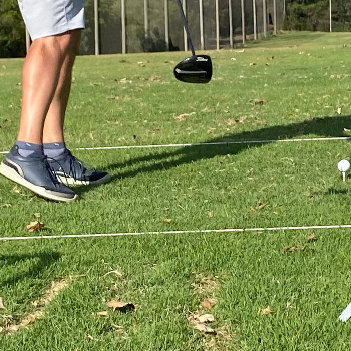 Legs of our golf guy, Marc, and the Rapsodo MLM2PRO during a swing at the golf range