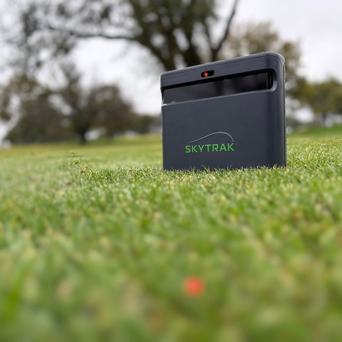 The SkyTrak ST MAX golf launch monitor on the grass at the golf course