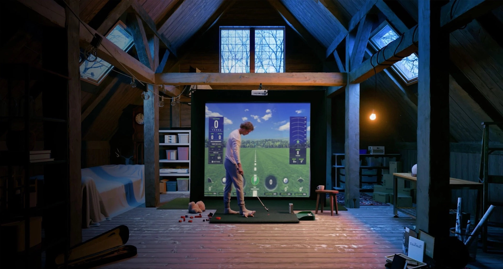 Golfer in a cool attic Skytrak golf simulator with virtual golf software on the golf impact screen