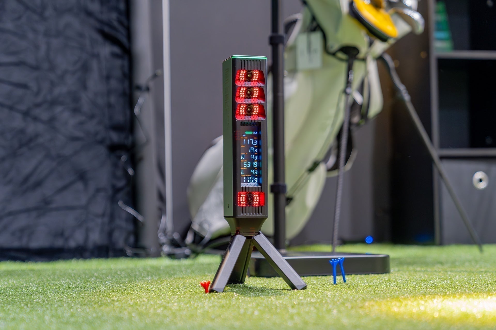 The Square Golf Omni launch monitor simulator powered up on a golf hitting mat