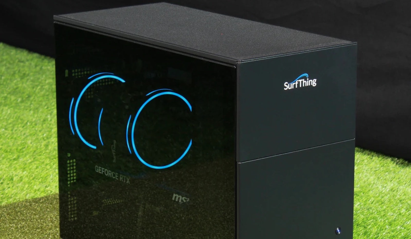 A SurfThing golf simulator computer sitting on a golf hitting mat