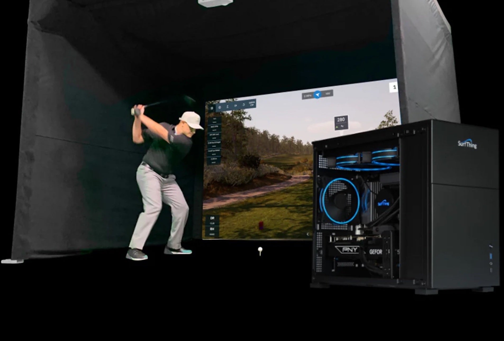 A SurfThing PC in the foreground with a golfer swinging in a big golf simulator with golf simulation software on the impact screen in the background