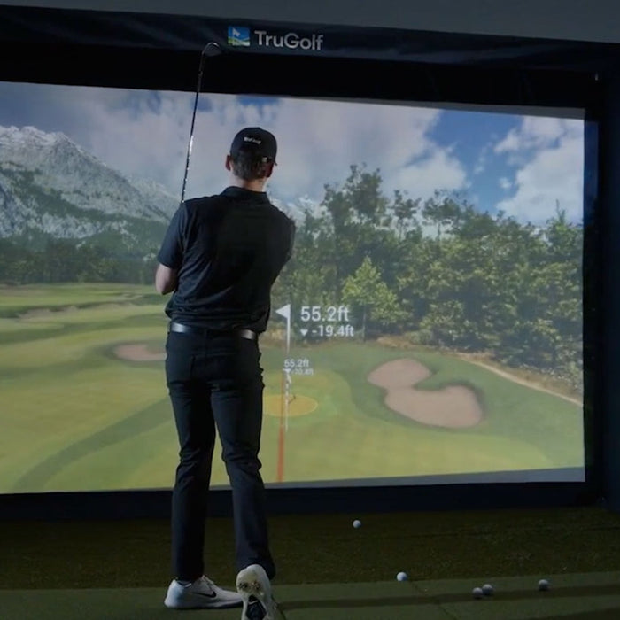 A golfer post swing in a TruGolf golf simulator