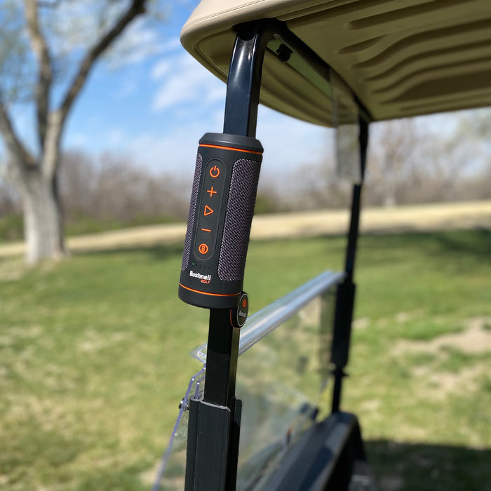 The Bushnell Wingman 2 golf speaker stuck to a golf cart pole by the magnet