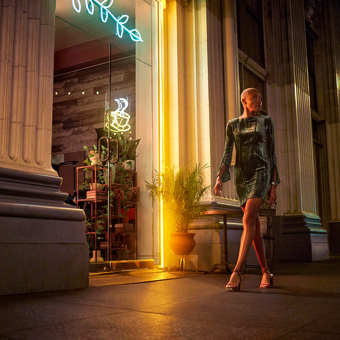 A woman outside a coffee shop dressed in evening wear and wearing a 42 mm Garmin epix Pro (Gen) 