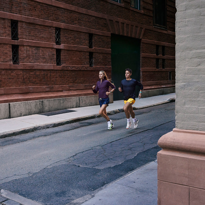 Two runner running out of an alley wearing Garmin Forerunner 265 running GPS watches