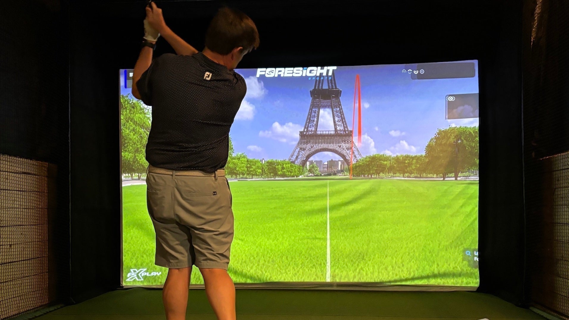 Marc post swing in a golf simulator playing Foresight Sports virtual golf 