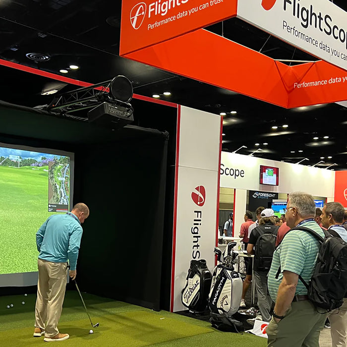 People gathered around the FlightScope golf simulator and display area at the 2024 PGA Show