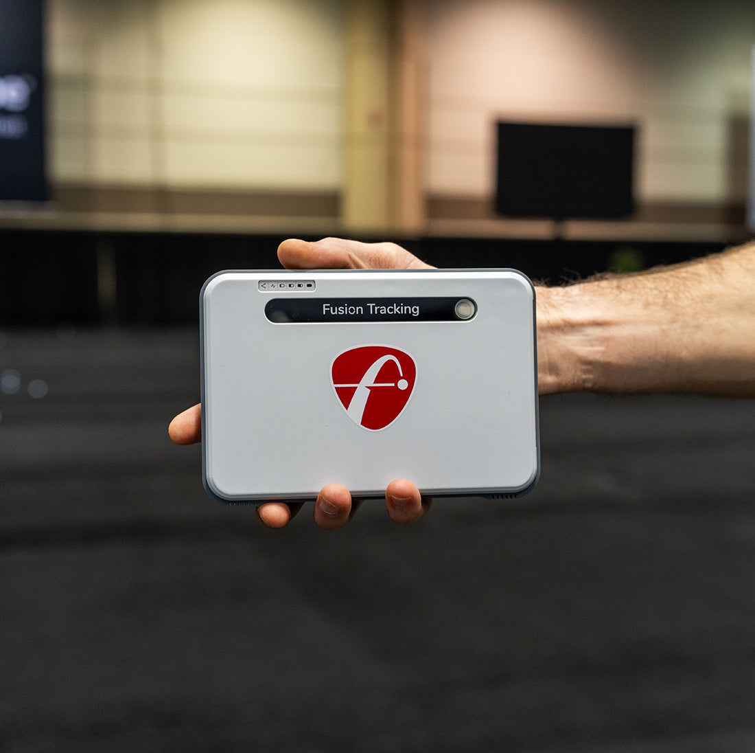 The FlightScope Mevo+ Limited Edition unit being held out in a hand at the FlightScope Display area at the 2024 PGA Show