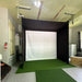 Vanish SportScreen retractable golf enclosure and impact screen in a garage with golf club bag, projector and mount, and golf hitting mat.