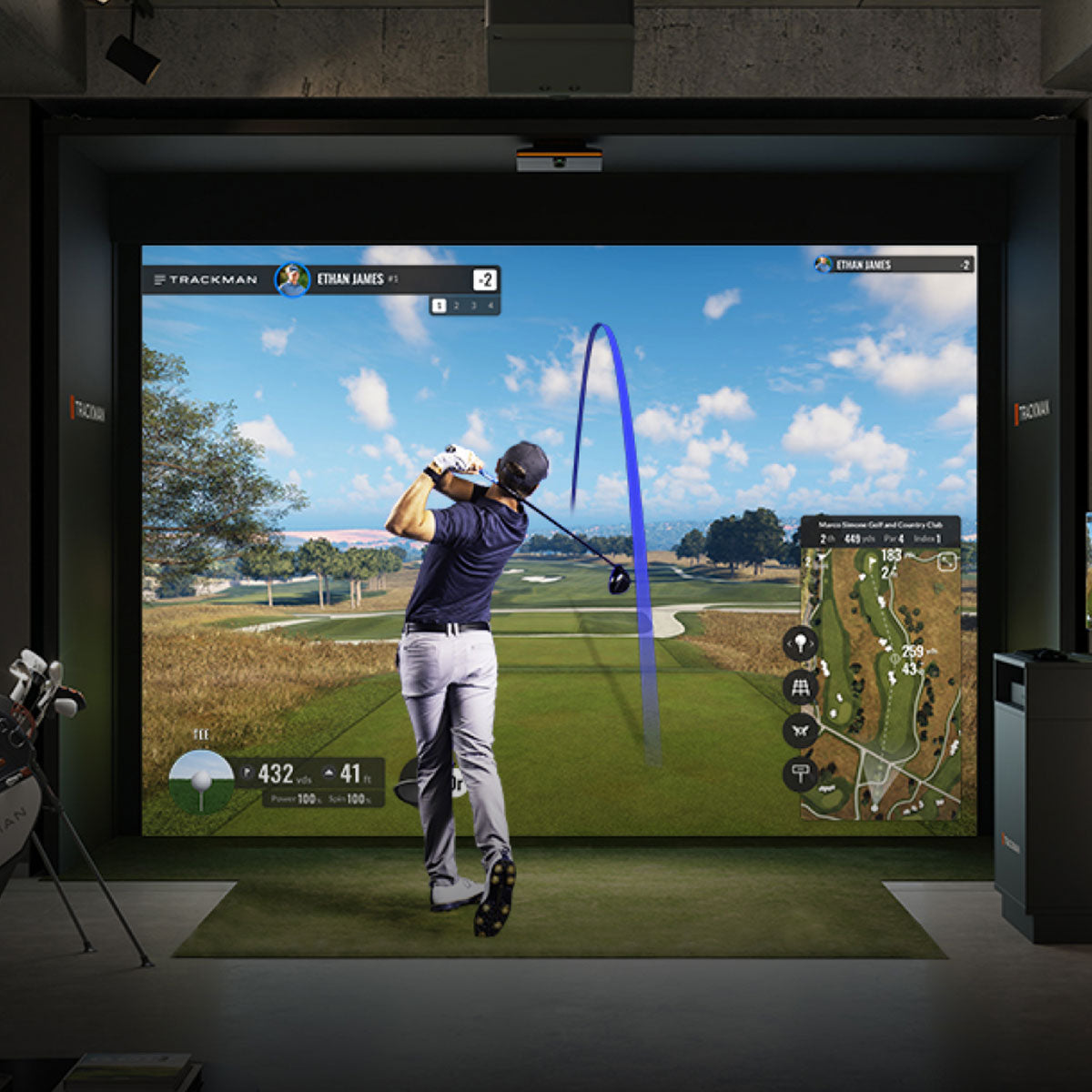 Trackman iO olf simulator setup with a screen displaying a golf game, showing a player swinging a club.